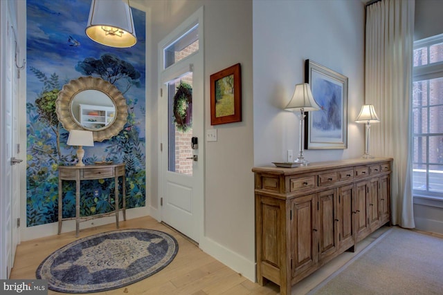 entryway with light wood-type flooring and baseboards