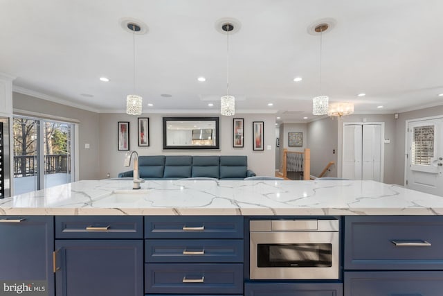 kitchen with crown molding, blue cabinets, and a kitchen island with sink