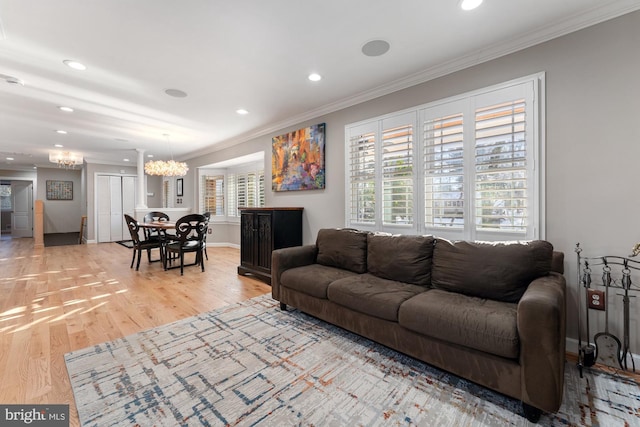 living room featuring hardwood / wood-style floors, ornamental molding, and a chandelier