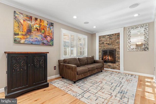 living room with a brick fireplace, wood-type flooring, and ornamental molding