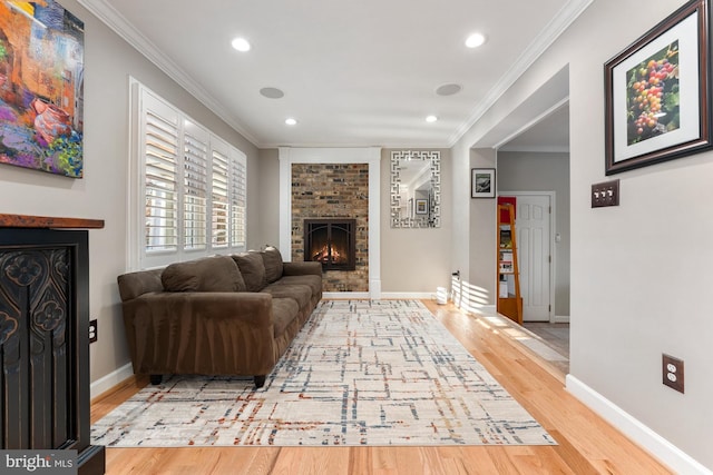 living room with hardwood / wood-style flooring, crown molding, and a brick fireplace