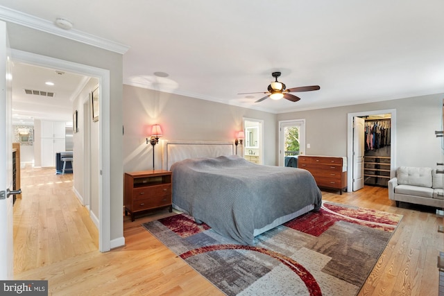 bedroom with ornamental molding, hardwood / wood-style floors, and ceiling fan