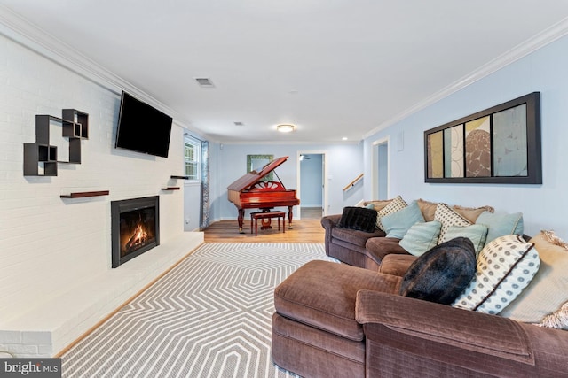 living room with crown molding and light hardwood / wood-style floors