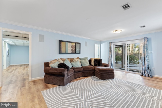 living room with ornamental molding and light hardwood / wood-style floors