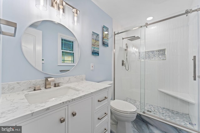 bathroom with vanity, toilet, and a shower with door