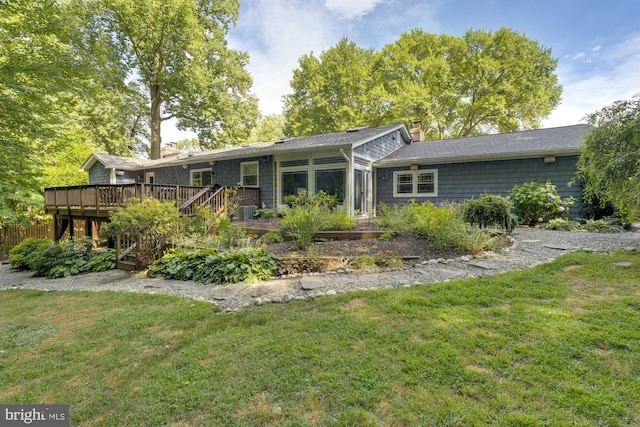 back of property featuring a lawn and a deck