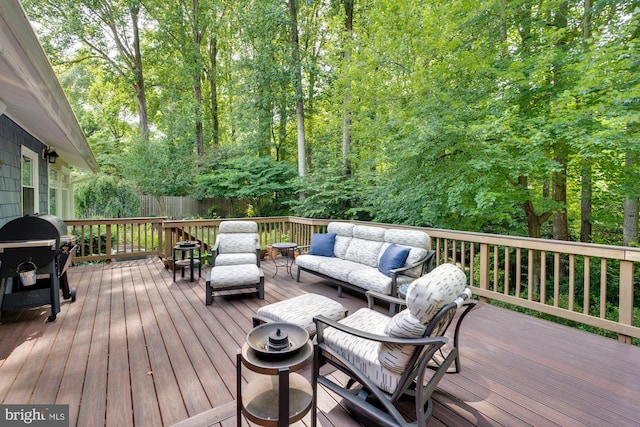 wooden deck featuring an outdoor living space and a grill