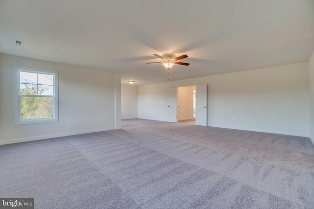 carpeted spare room with ceiling fan