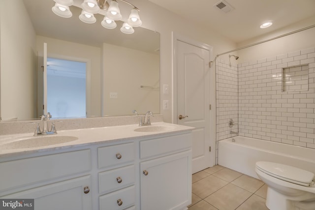 full bathroom with tile patterned flooring, vanity, tiled shower / bath combo, and toilet