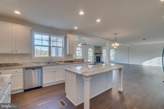 kitchen with white cabinetry, hanging light fixtures, dishwasher, and a kitchen island