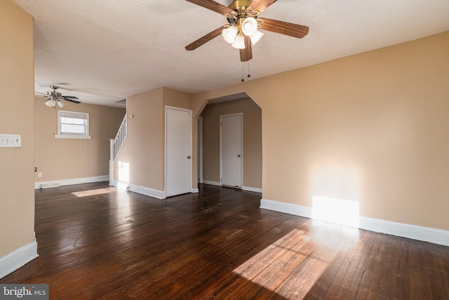 empty room with ceiling fan, dark wood-type flooring, and a textured ceiling