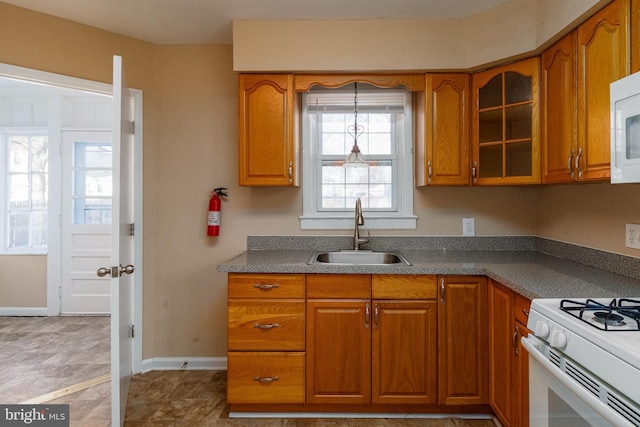 kitchen featuring pendant lighting, sink, and gas range gas stove