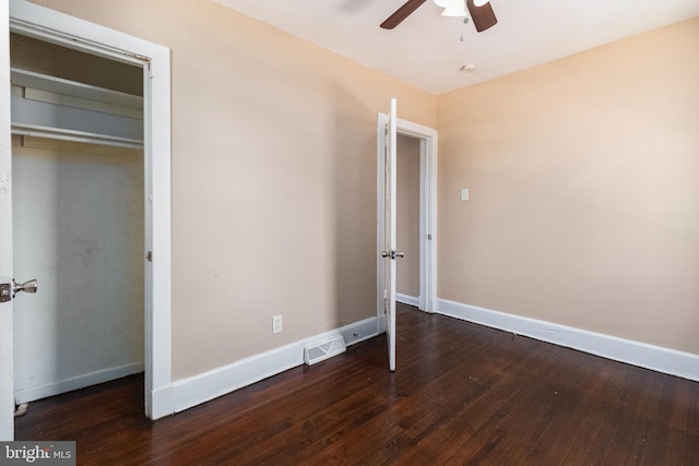 unfurnished bedroom with dark wood-type flooring, ceiling fan, and a closet