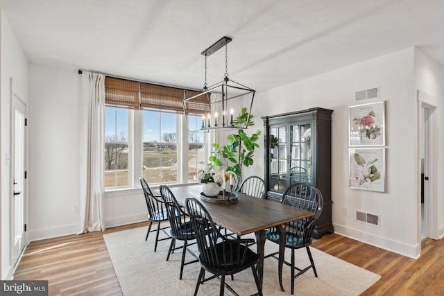 dining space with hardwood / wood-style flooring and a chandelier