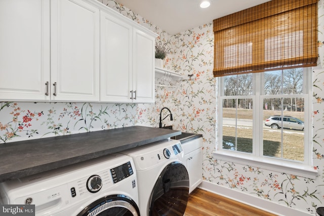 washroom with cabinets, separate washer and dryer, sink, and light hardwood / wood-style flooring