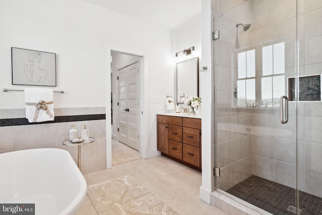 bathroom featuring vanity, shower with separate bathtub, tile patterned flooring, and tile walls