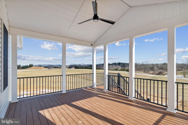 unfurnished sunroom with a rural view, vaulted ceiling, and ceiling fan