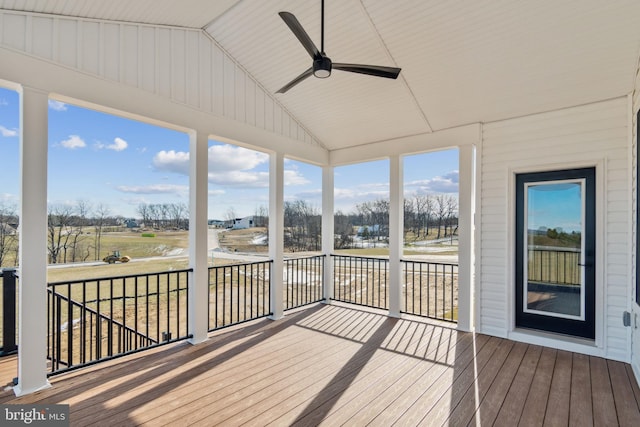 unfurnished sunroom featuring ceiling fan, a healthy amount of sunlight, and vaulted ceiling