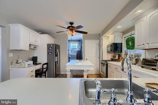 kitchen with white cabinetry, ceiling fan, stainless steel appliances, and a wealth of natural light