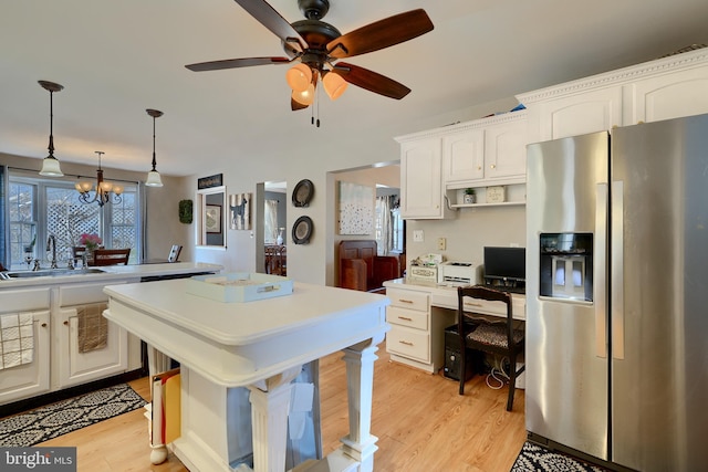 kitchen featuring white cabinetry, sink, stainless steel fridge with ice dispenser, and hanging light fixtures