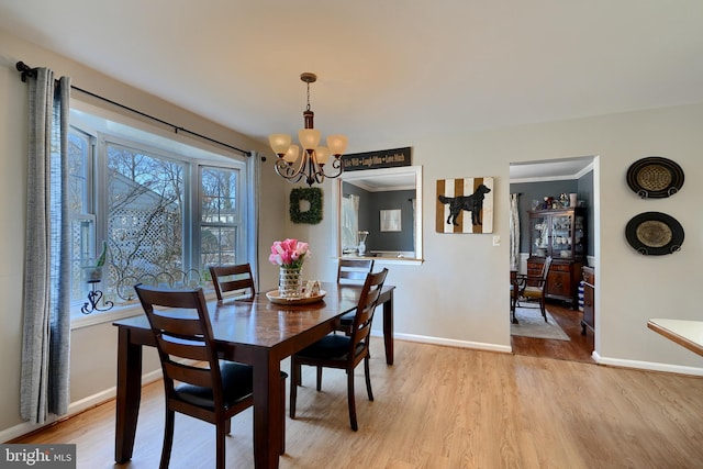 dining room featuring a healthy amount of sunlight, a notable chandelier, and light hardwood / wood-style floors