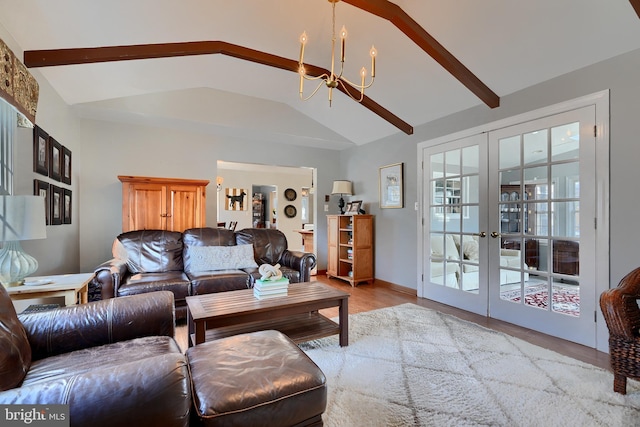 living room featuring vaulted ceiling with beams, a notable chandelier, light wood-type flooring, and french doors