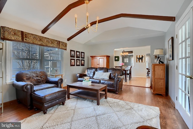 living room featuring lofted ceiling with beams, wood-type flooring, and a chandelier