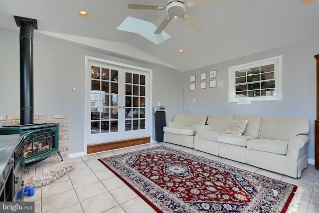 tiled living room with french doors, ceiling fan, lofted ceiling, and a wood stove