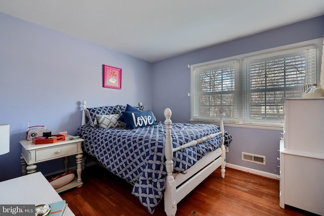 bedroom with dark hardwood / wood-style flooring and multiple windows