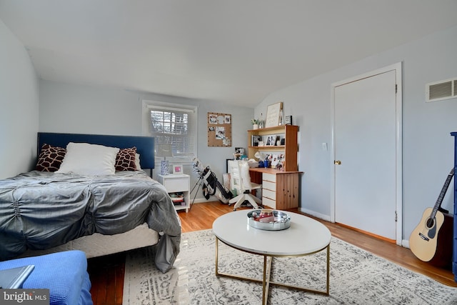 bedroom featuring lofted ceiling and hardwood / wood-style floors