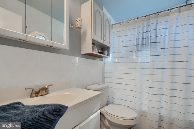 bathroom with walk in shower, vanity, toilet, and backsplash