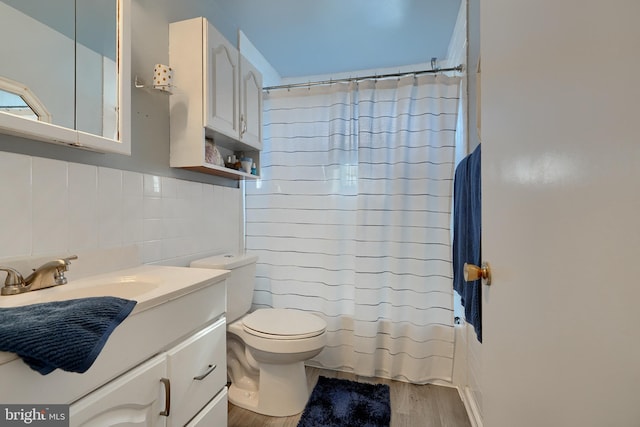 full bathroom with hardwood / wood-style floors, shower / tub combo with curtain, tasteful backsplash, vanity, and toilet