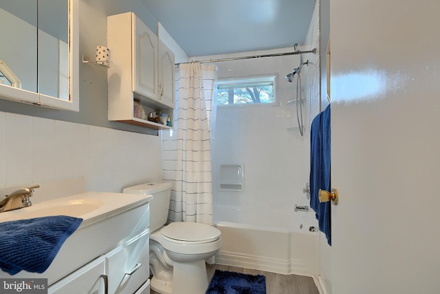 full bathroom featuring tile walls, hardwood / wood-style floors, vanity, toilet, and shower / bath combo with shower curtain