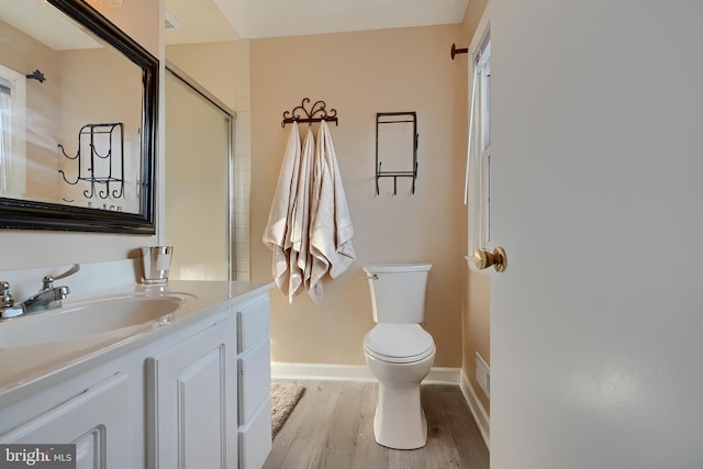 bathroom with vanity, toilet, hardwood / wood-style floors, and a shower with shower door