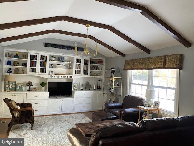 living room with an inviting chandelier and lofted ceiling