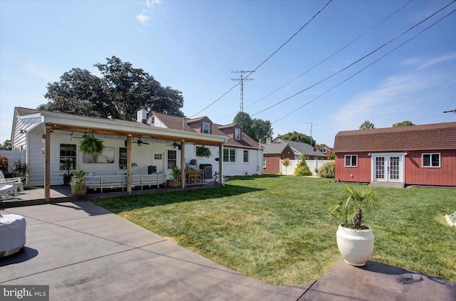 view of front of home with an outbuilding, a front yard, and ceiling fan