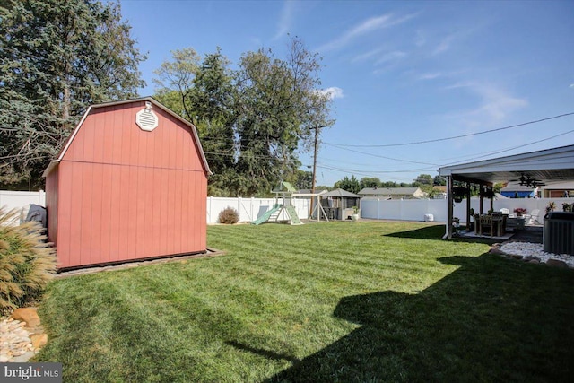 view of yard featuring central AC unit, a storage shed, and a playground