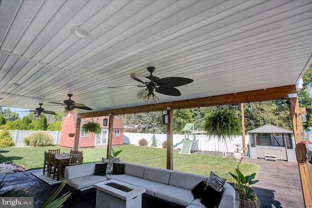 view of patio / terrace with an outdoor structure, an outdoor living space with a fire pit, a playground, and a water view