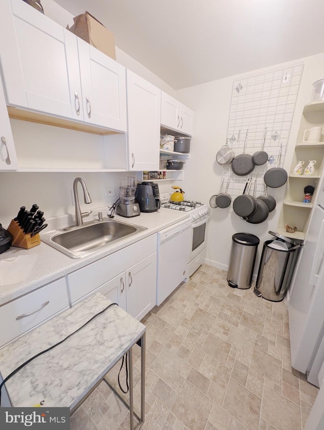 kitchen with white appliances, sink, and white cabinets