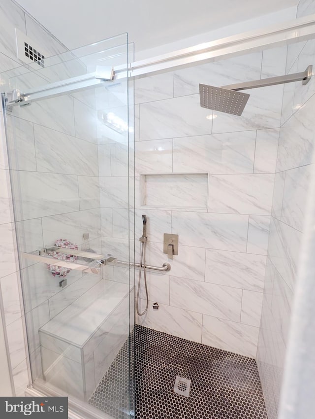 bathroom with a shower with door