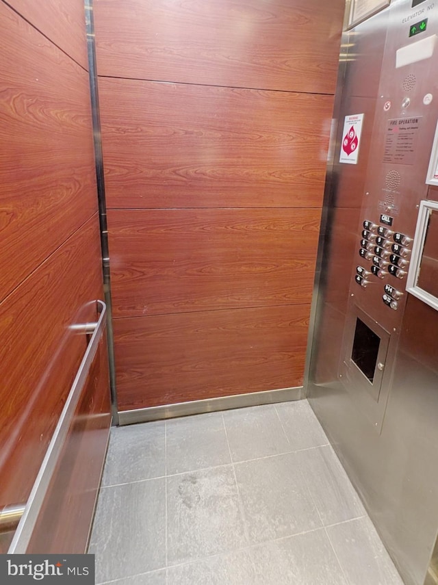 interior space featuring elevator and wood walls