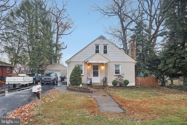 view of front of house featuring a garage, an outdoor structure, and a front yard