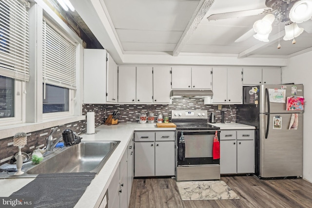 kitchen featuring tasteful backsplash, stainless steel appliances, beam ceiling, and sink