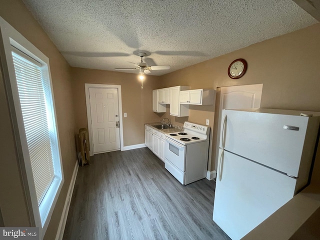 kitchen with a textured ceiling, white appliances, wood finished floors, a sink, and white cabinets