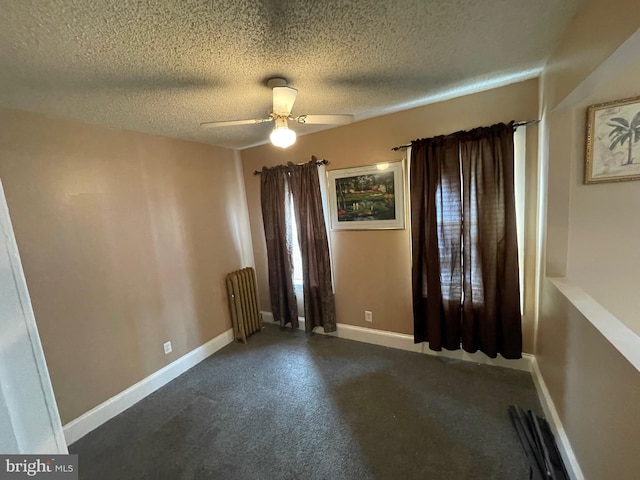 unfurnished room featuring baseboards, ceiling fan, a textured ceiling, and radiator