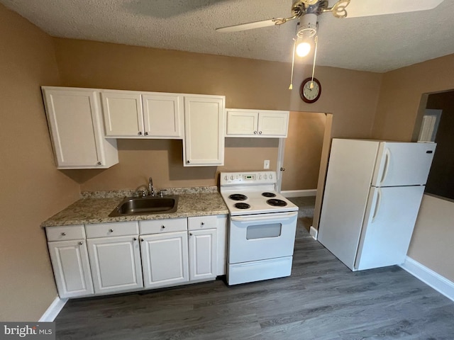 kitchen with white appliances, dark wood finished floors, a textured ceiling, white cabinetry, and a sink