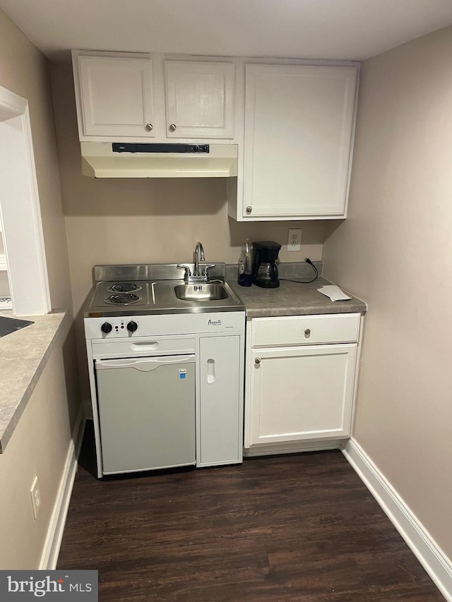 kitchen featuring dark wood-style floors, white cabinets, a sink, and under cabinet range hood