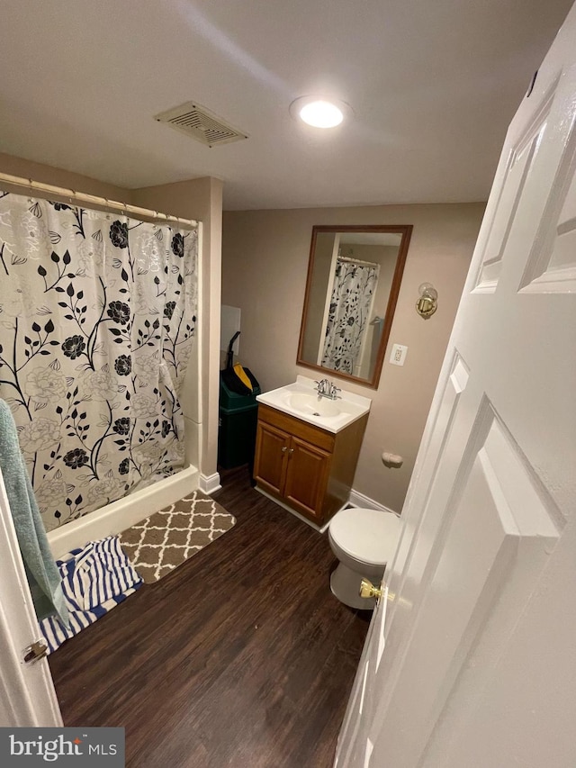 full bathroom featuring baseboards, visible vents, toilet, wood finished floors, and vanity