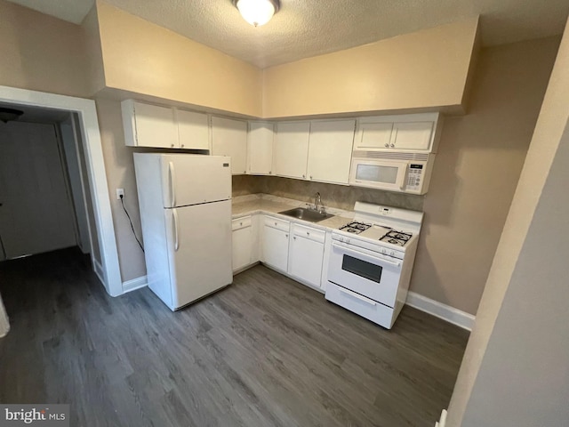 kitchen featuring white appliances, baseboards, dark wood-style flooring, a textured ceiling, and a sink