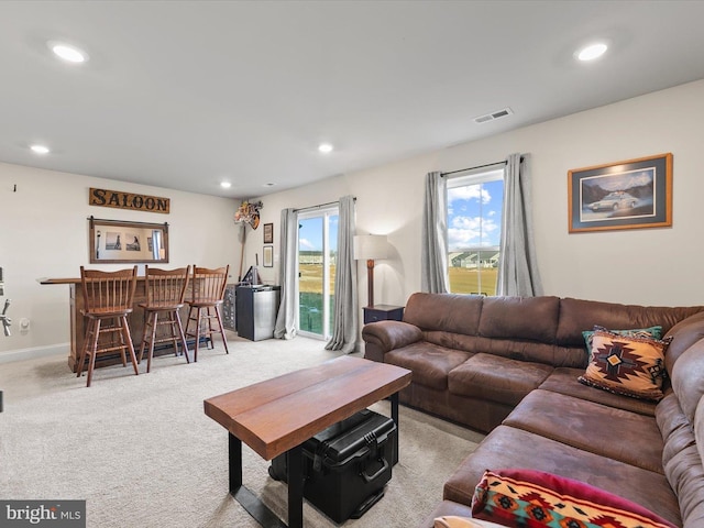 living room featuring indoor bar and light carpet